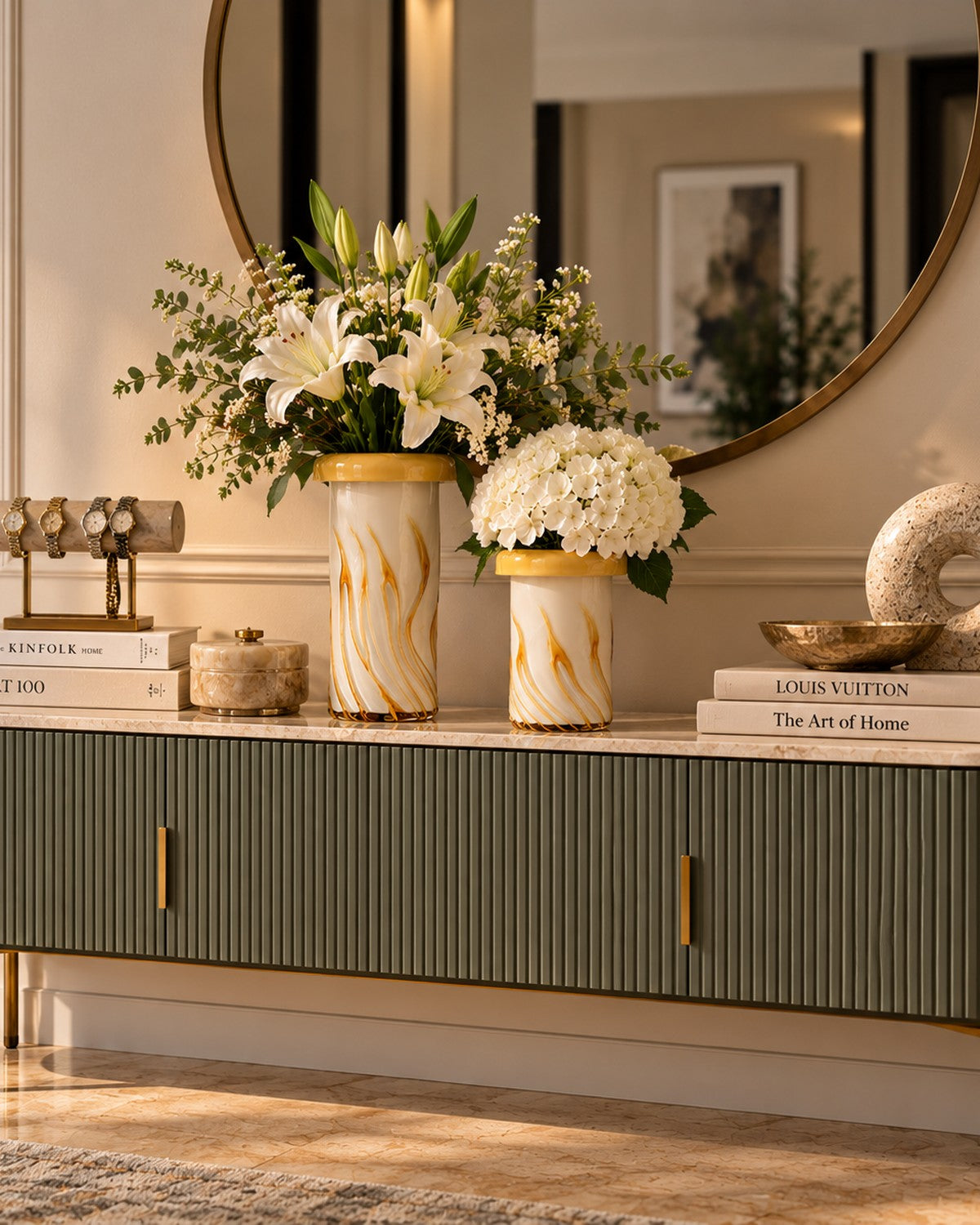 Styled on a console: a yellow-striped vase holds white lilies and greenery