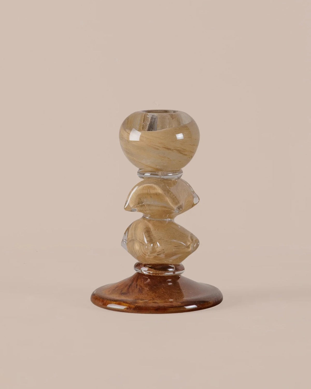 On a plain background: Stacked pebble-like holder with golden swirled top and clear middle sections