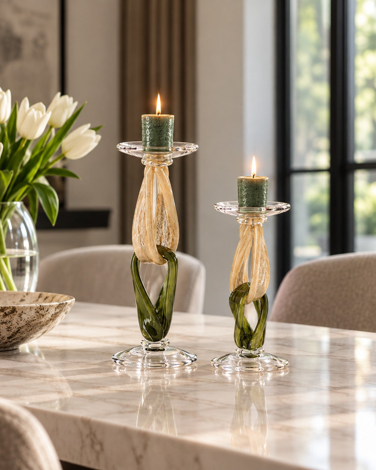 Styled on a marble table, a green glass candlestick holds a lit candle
