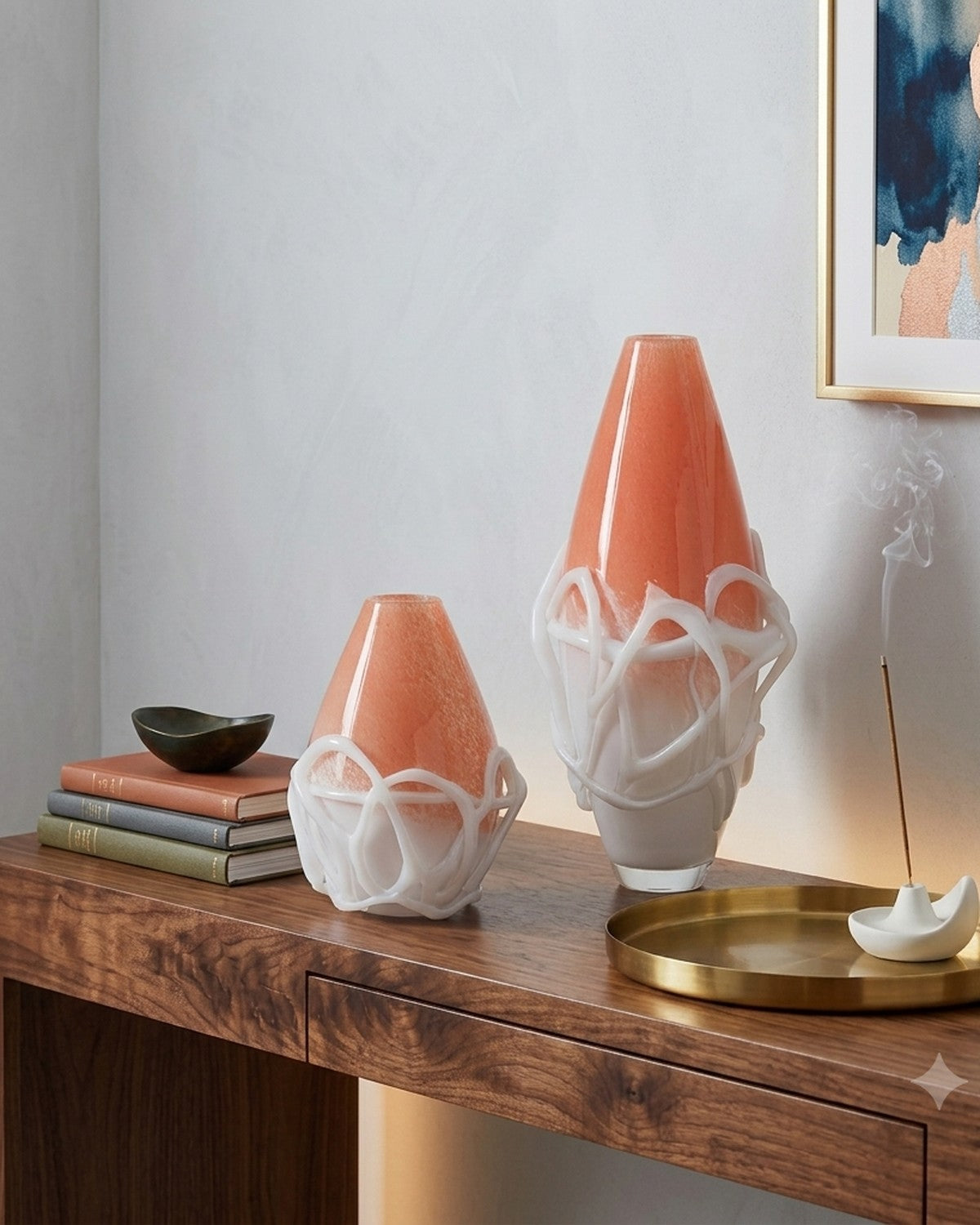 Styled on a console: Two orange and white veined vases on a wooden surface