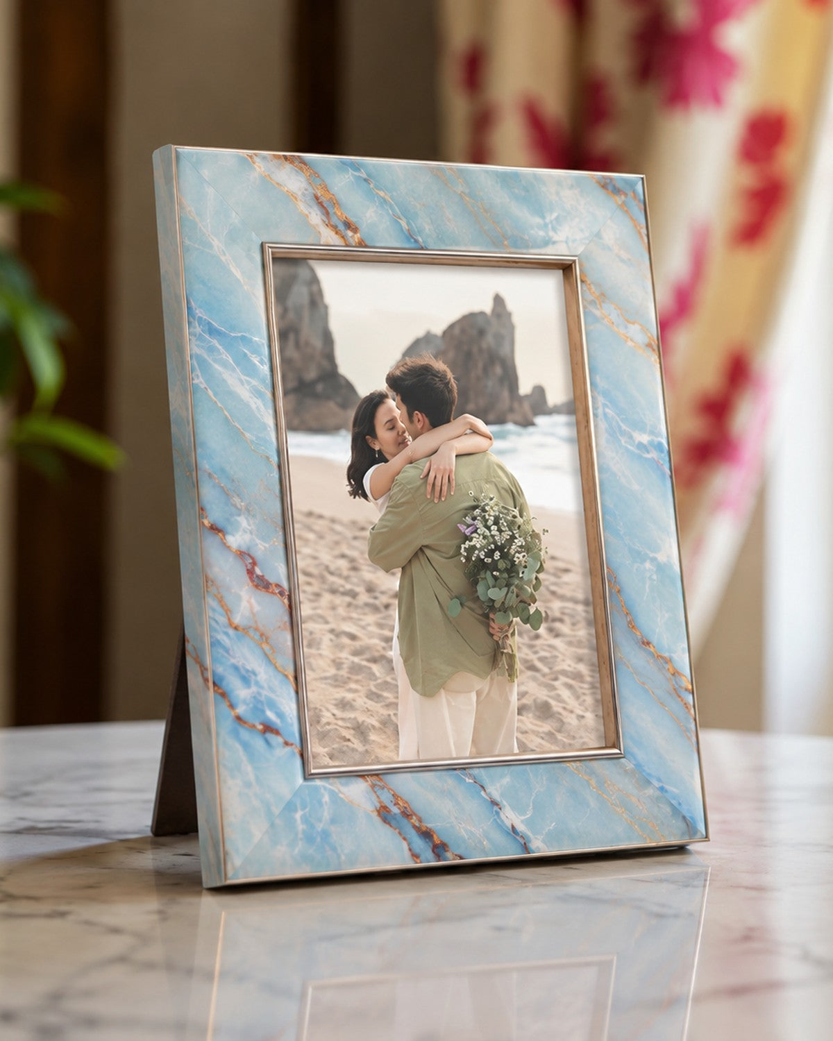 Close-up of a blue and gold photo frame displaying a couple on a beach