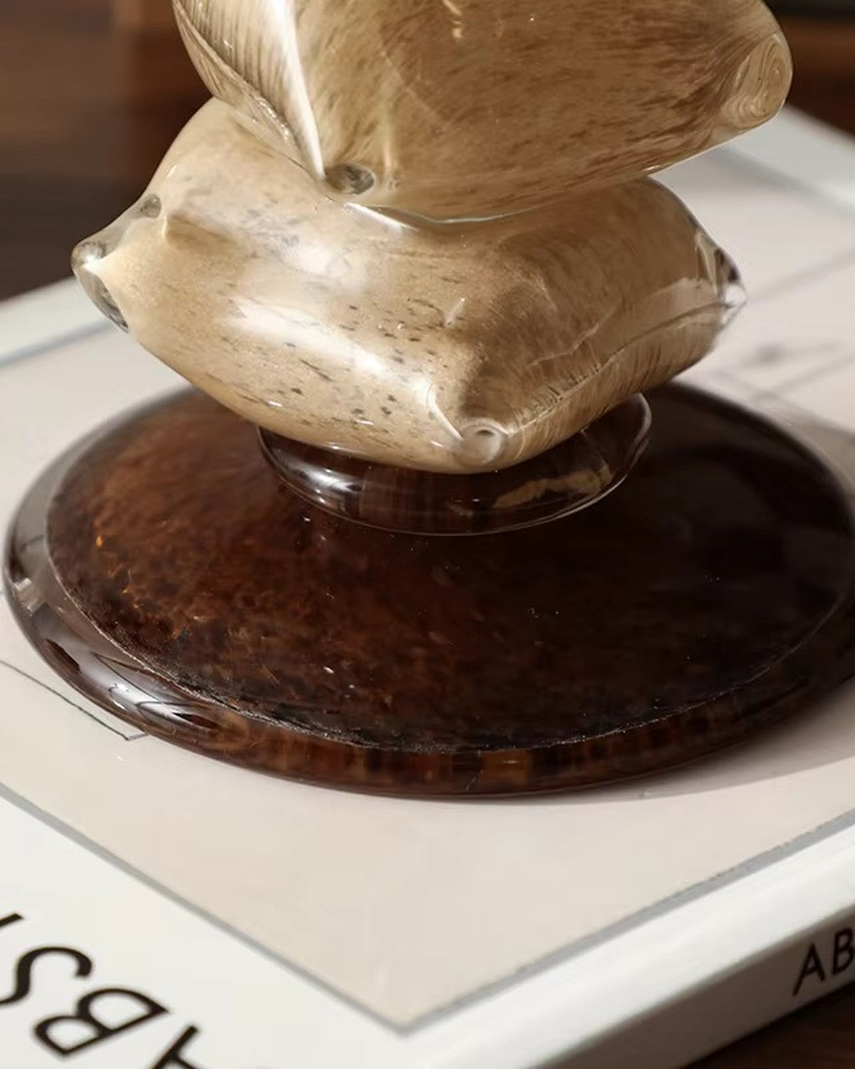 Close-up of stacked, translucent, speckled light brown irregular forms on a dark round base